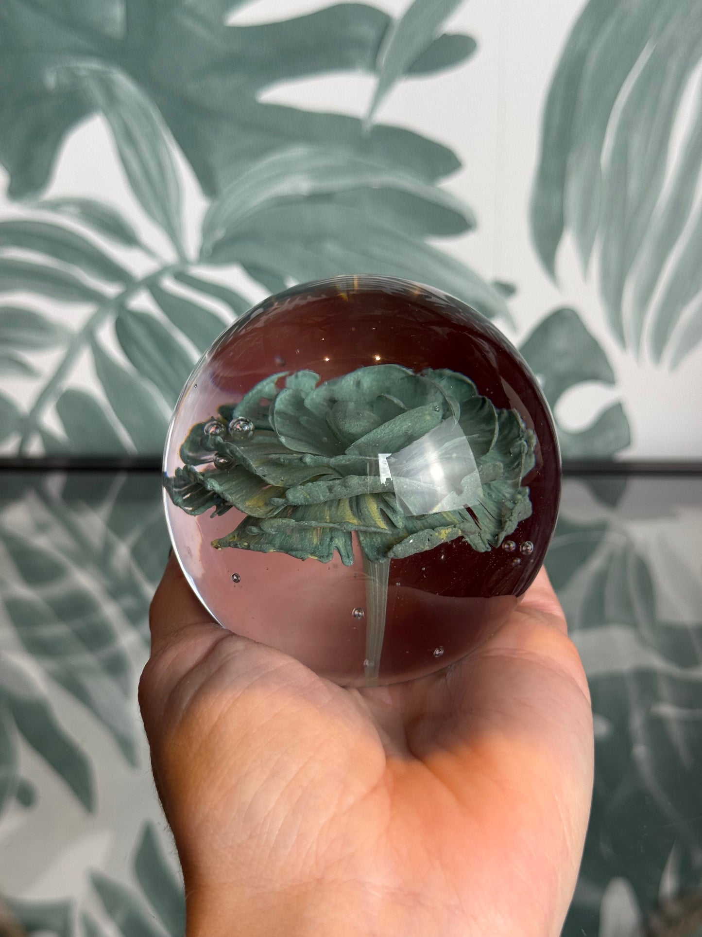Glazen bol met groene bloem