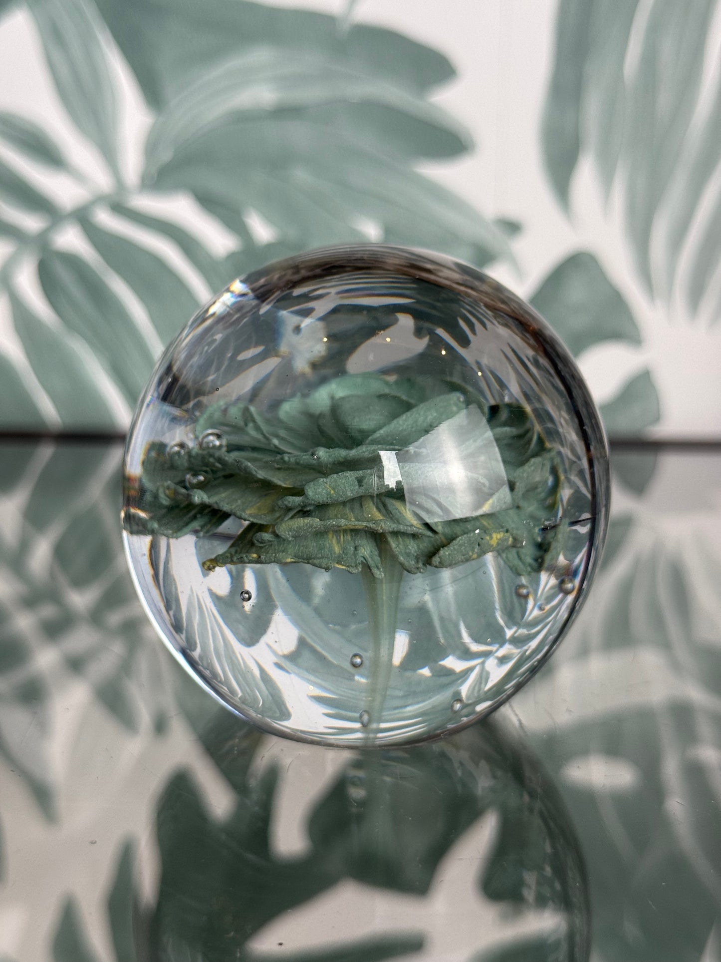 Glazen bol met groene bloem