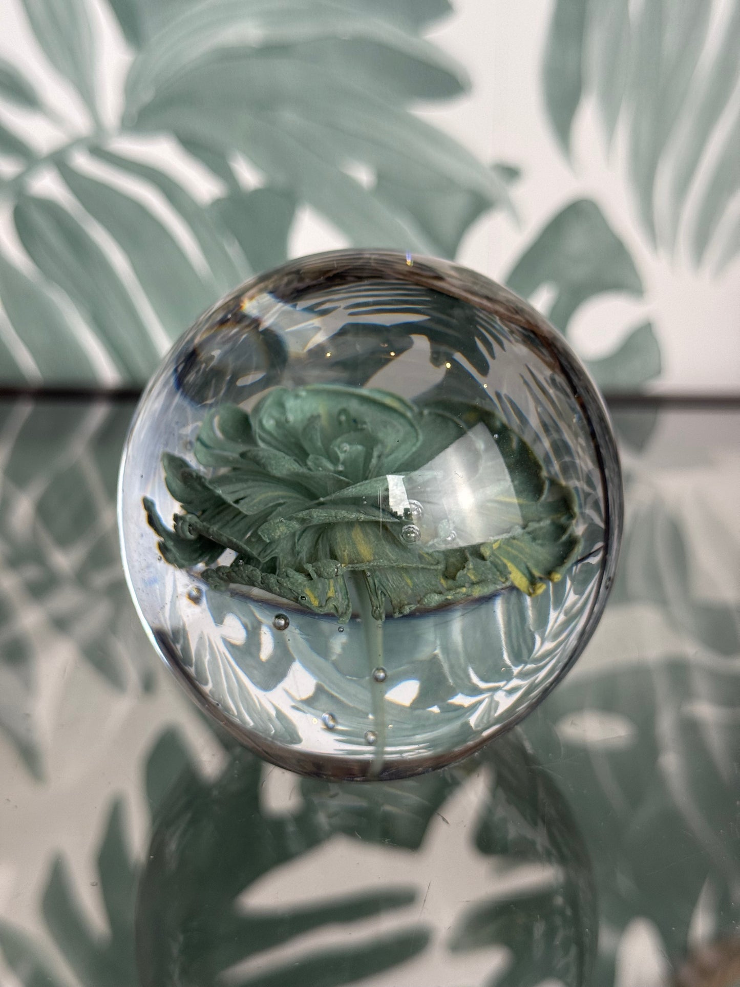 Glazen bol met groene bloem